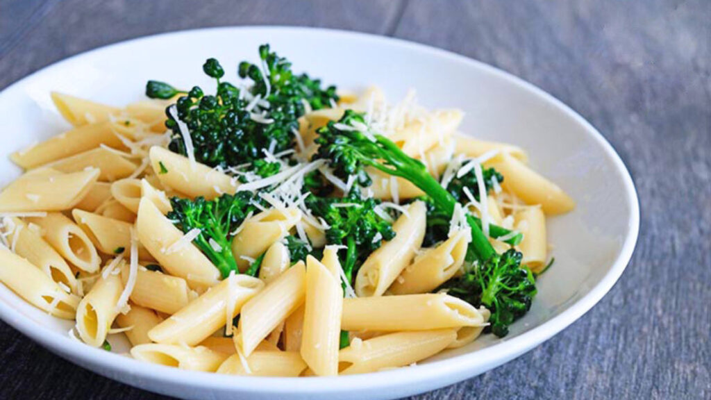 Horizontal shot of this garlicky broccolini pasta recipe served in a white bowl.