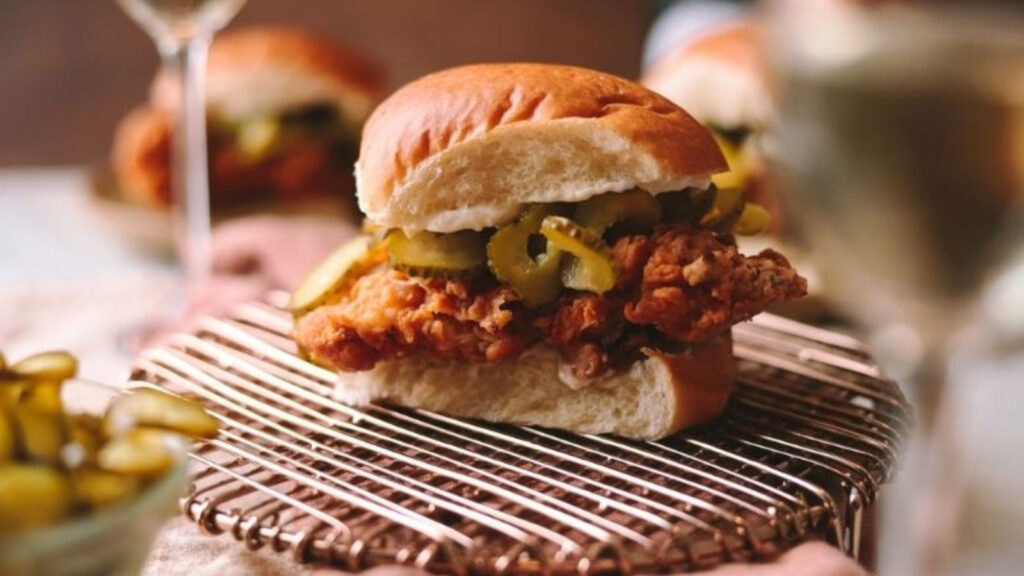 A buttermilk chicken sandwich on a rack, sitting on a table.