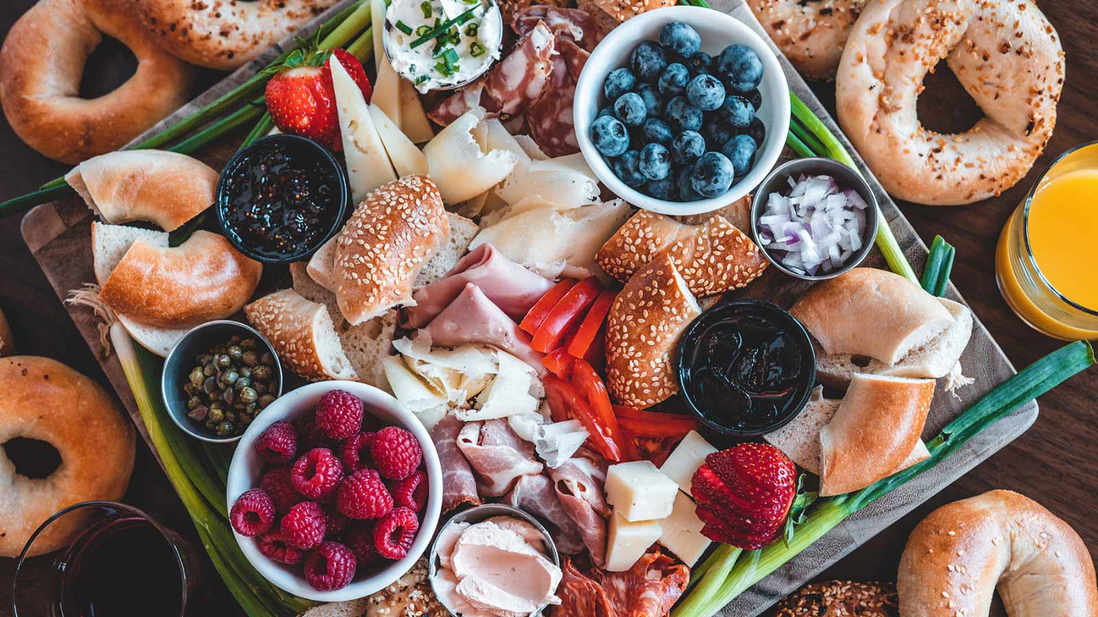 Flat Lay Bagel Brunch Board with cheese and fruit.
