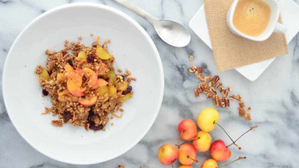 An overhead view of a white bowl with cherry pie oatmeal in it.