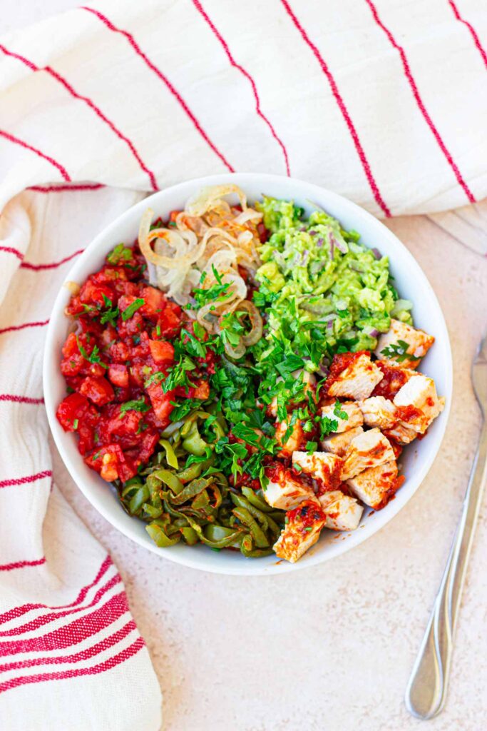 An overhead view of a white bowl filled with Avocado Chicken Salad.