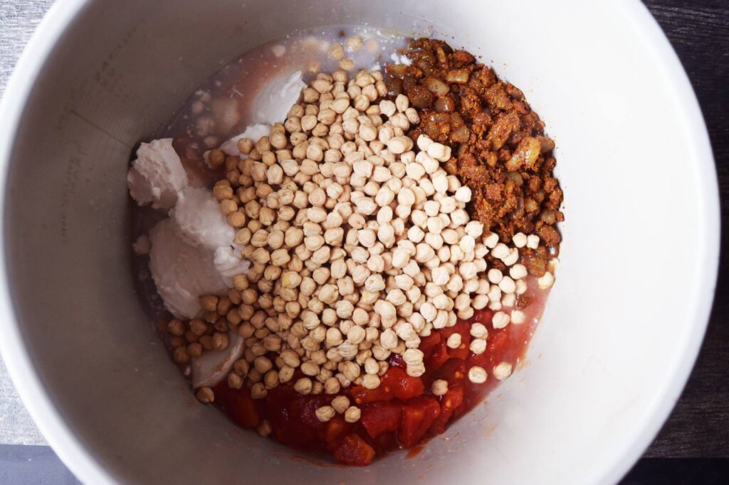 Ingredients for this Chickpea Curry Recipe added to a crock for pressure cooking or slow cooking.