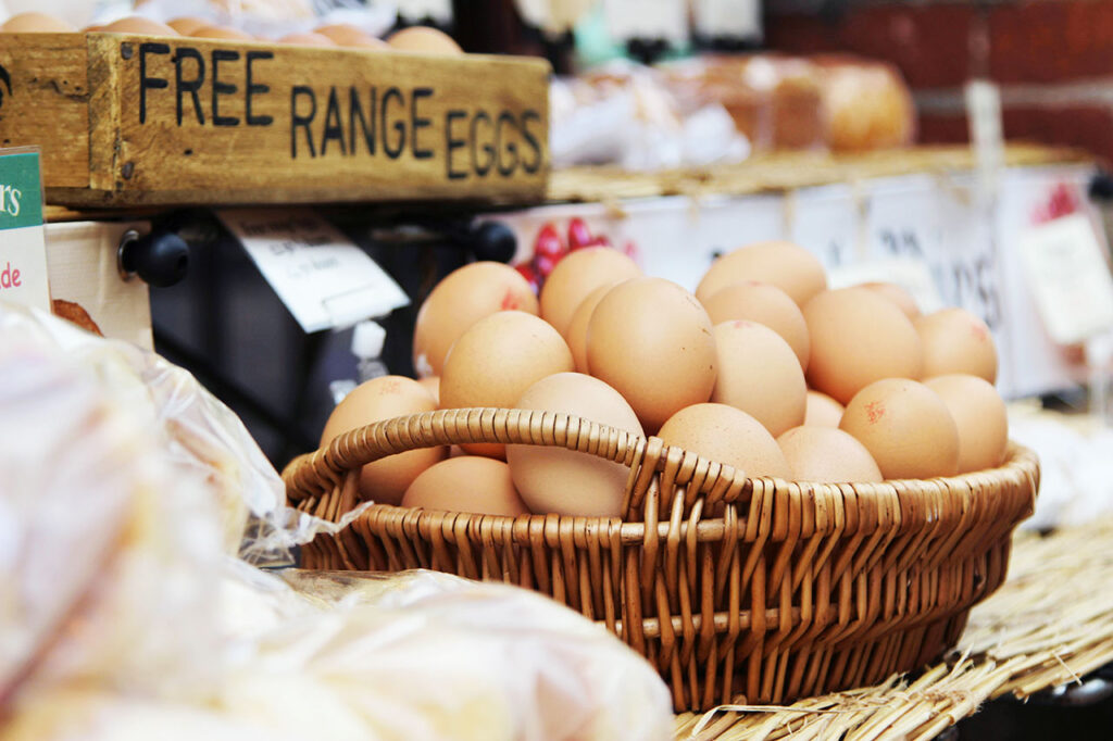 A basket of eggs sitting on a counter at a farmer's market.