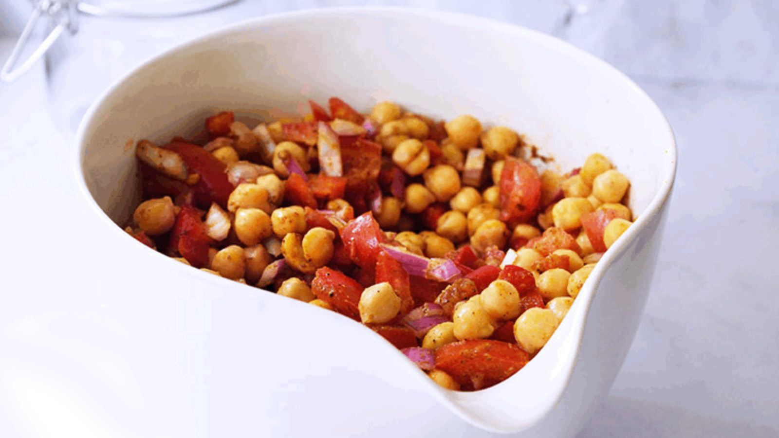 A large, white mixing bowl filled with Indian Chickpea Salad.