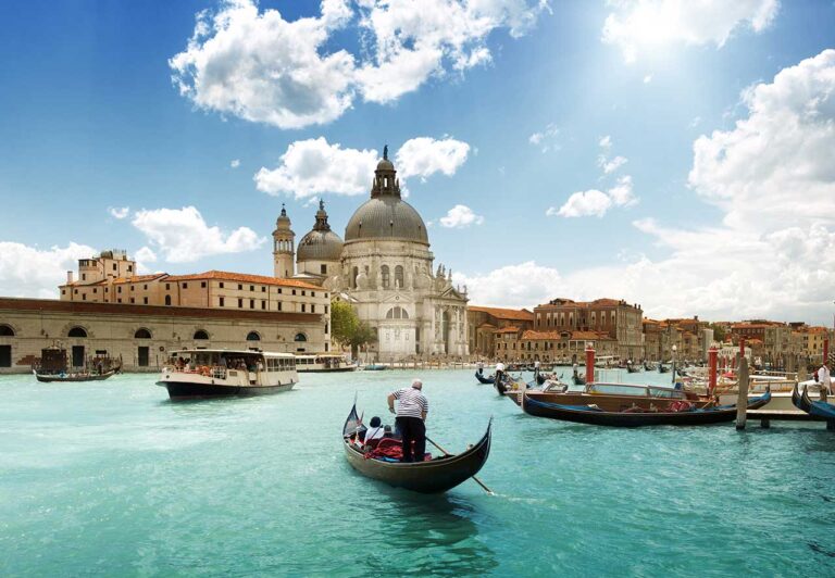 A view of a Venice waterway with gondolas on it.