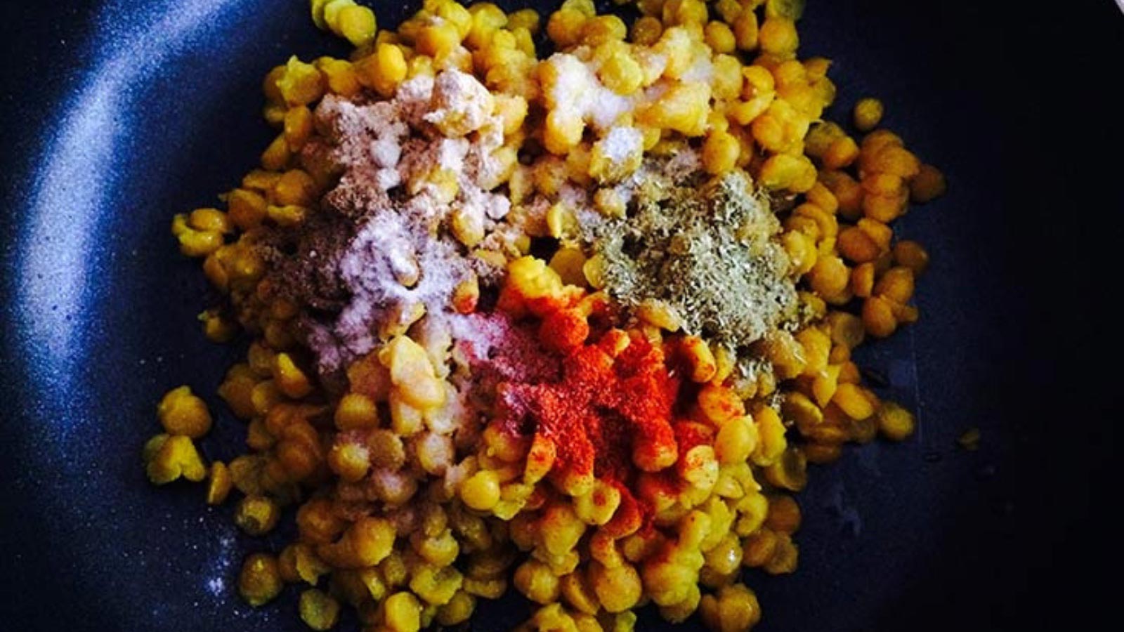 A skillet filled with lentil hash and spices.