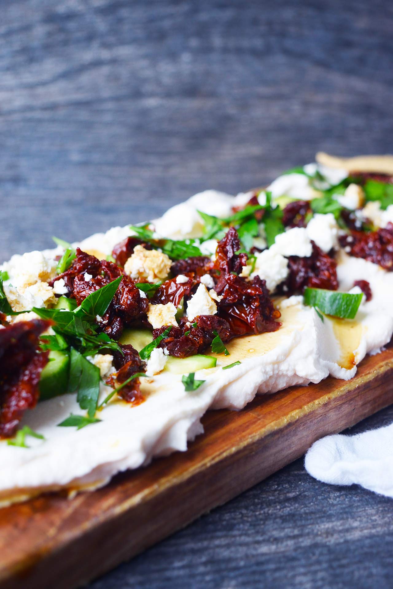 A side view of a charcuterie board spread with Mediterranean Cream Cheese Dip.