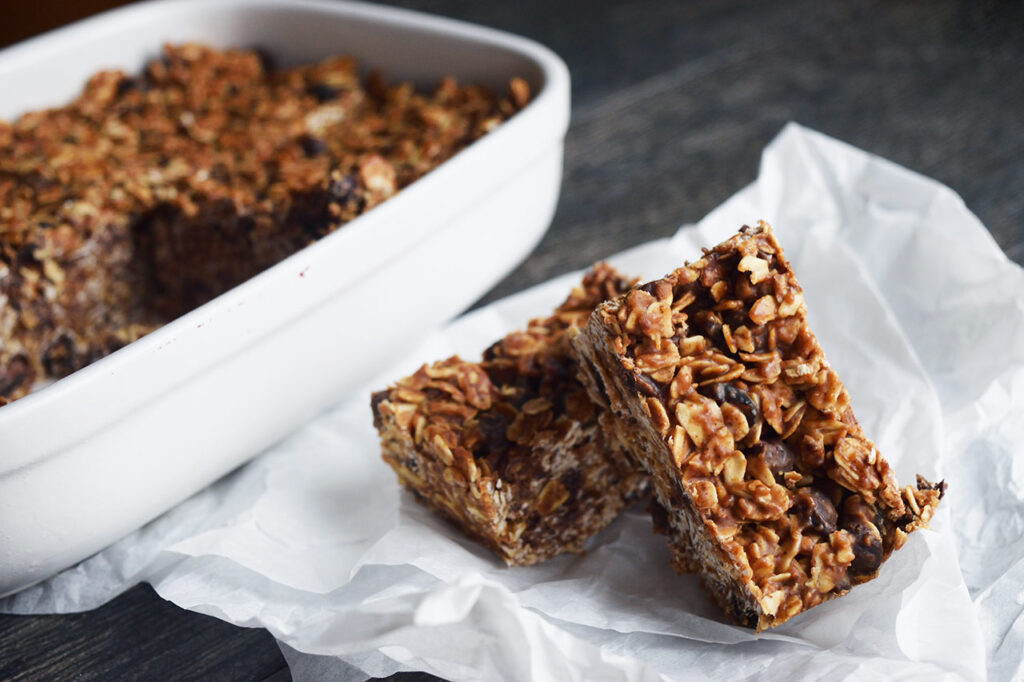 Two Homemade Granola Bars on a piece of parchment paper.