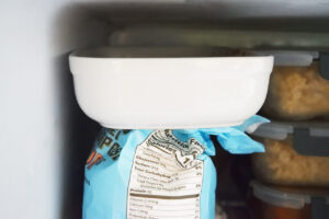 A white casserole dish of No Bake Granola Bars sitting in a freezer.