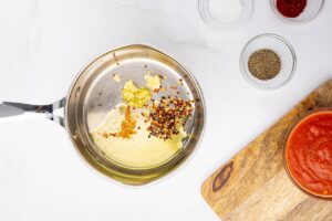 Olive oil heating in a pot with spices.