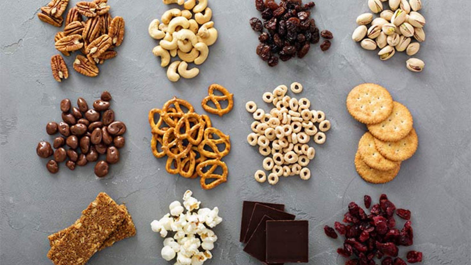 Small portions of various snacks on a gray background.