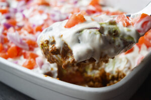 A spoonful of Taco Salad Casserole from a white casserole dish.