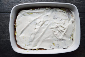 A layer of yogurt spread over a Taco Salad Casserole.