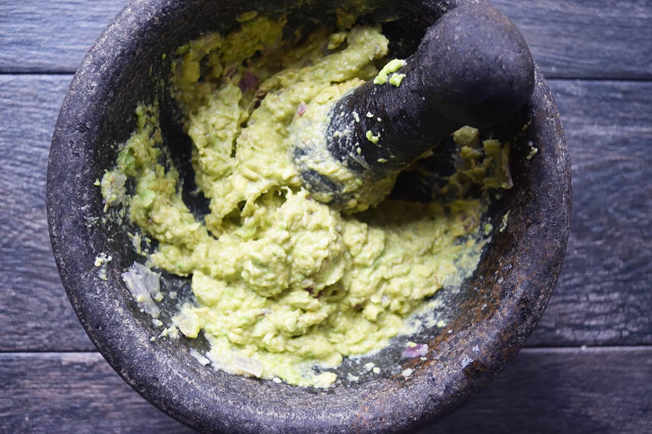 A morter and pestle with guacamole.
