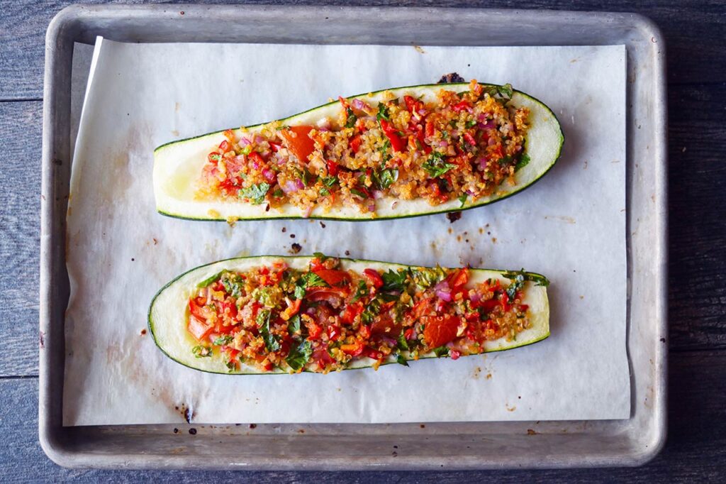Baked zucchini boats cooling on a baking sheet.