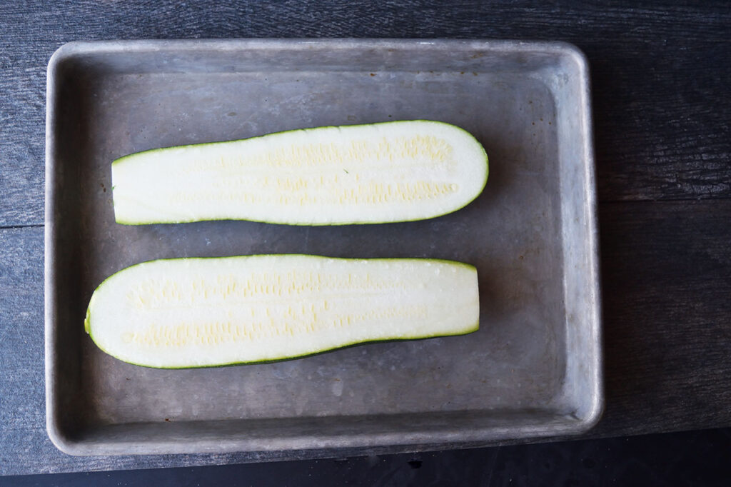 A large zucchini cut in half lengthwise.