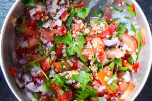 A closeup of zucchini boat stuffing, mixed in a metal mixing bowl.