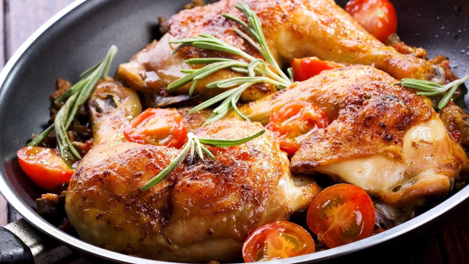 Roasted chicken legs with vegetables and herbs.