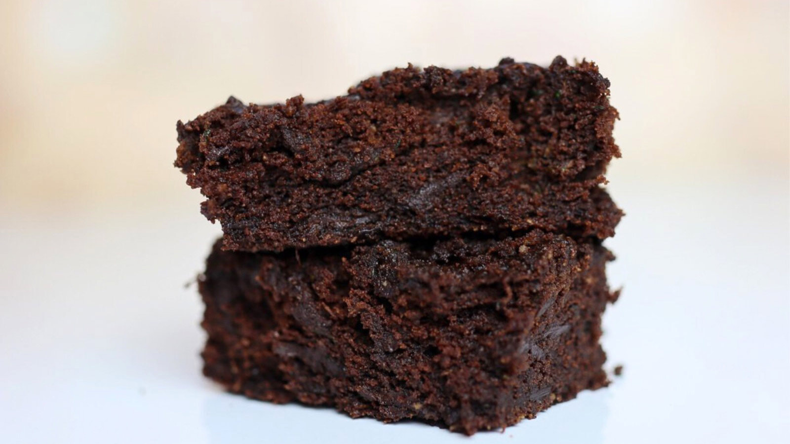 A stack of two brownies on a white background.