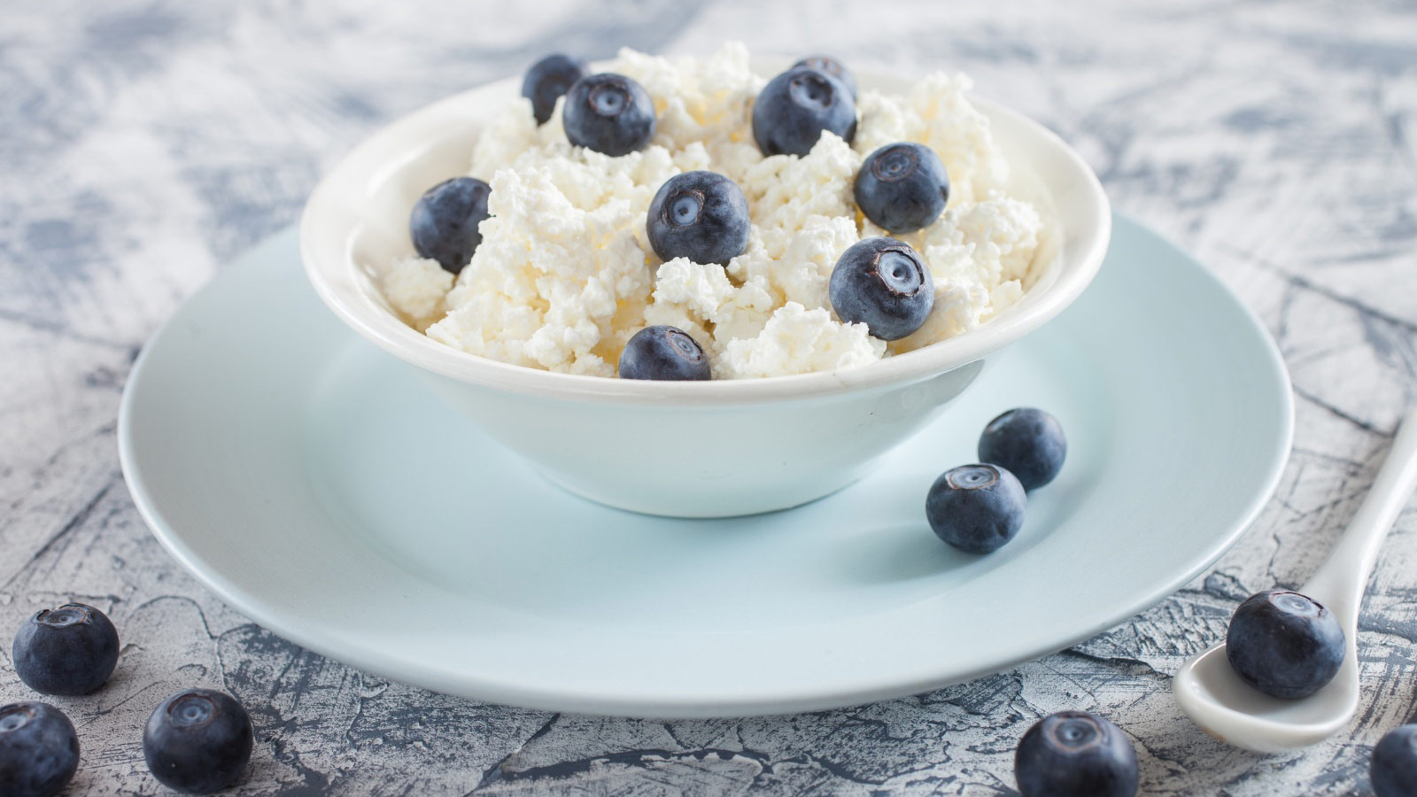 Cottage cheese and blueberry in a bowl on a table.