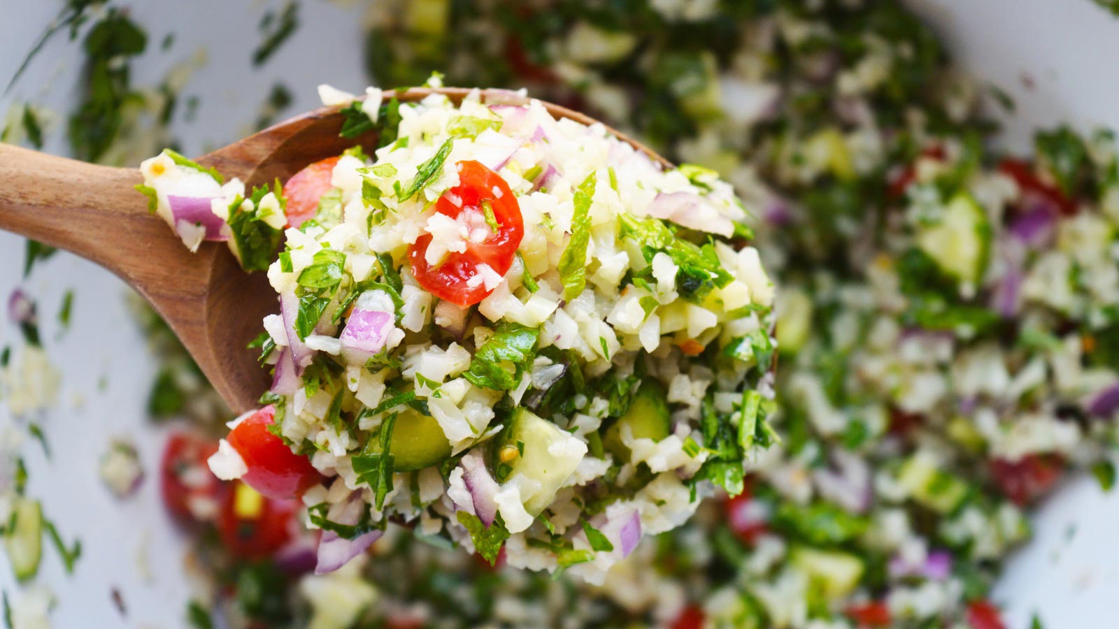 A wooden spoon full of Cauliflower Tabbouleh.