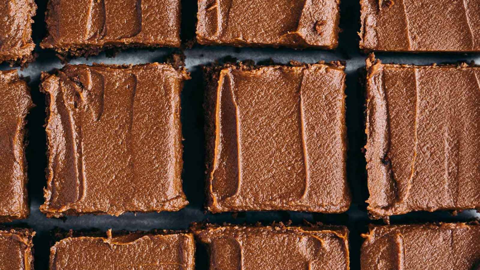 An overhead closeup of cut brownies sitting on parchment paper.