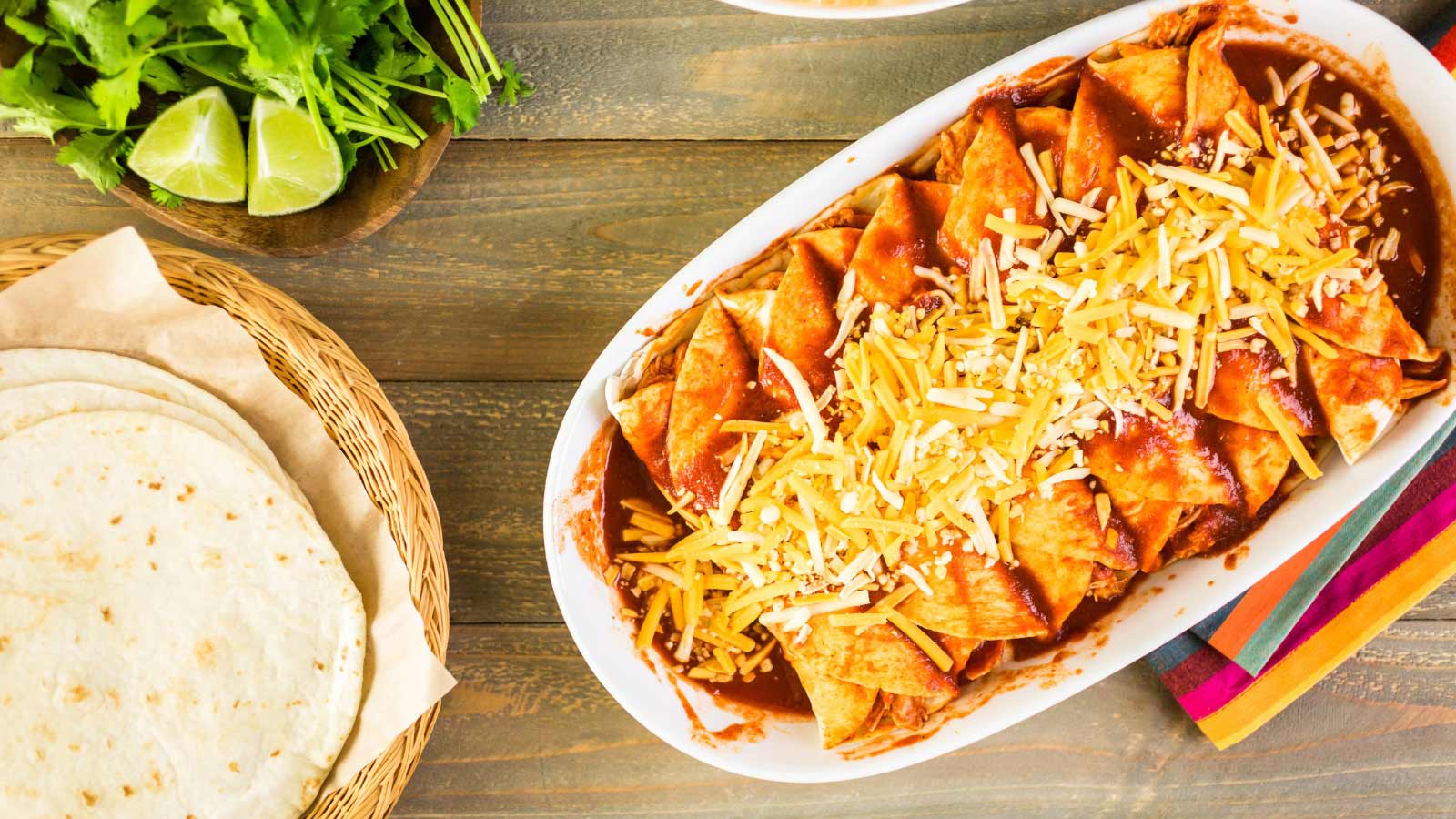 Homemade chicken enchiladas in a white casserole dish.