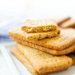 A stack of graham crackers on a white platter.