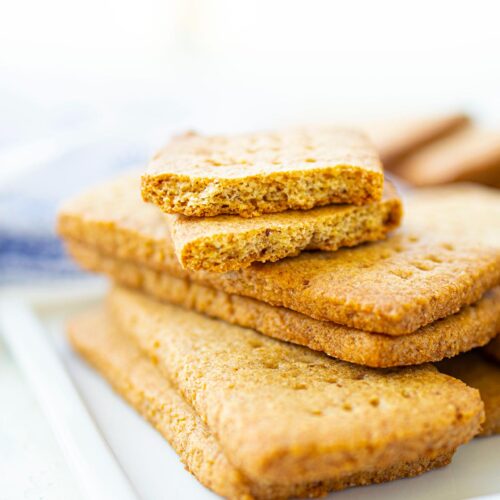 A stack of graham crackers on a white platter.