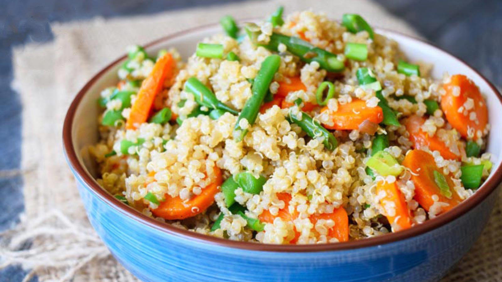 A blue bowl filled with easy quinoa salad.