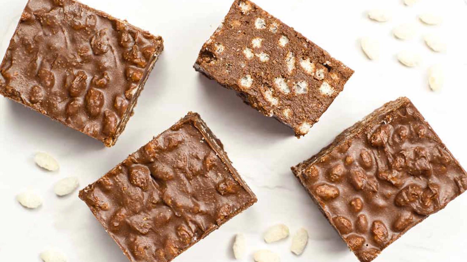 Four Homemade Crunch Bars laying on a white surface.