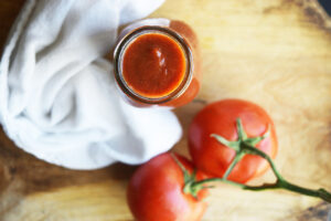 An overhead view of a glass jar filled with Ketchup.