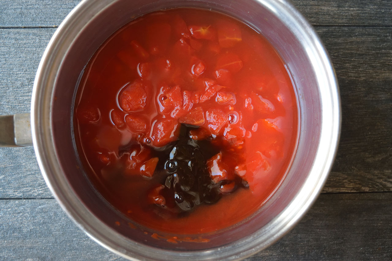 Tomatoes, vinegar, and maple syrup in a pot.