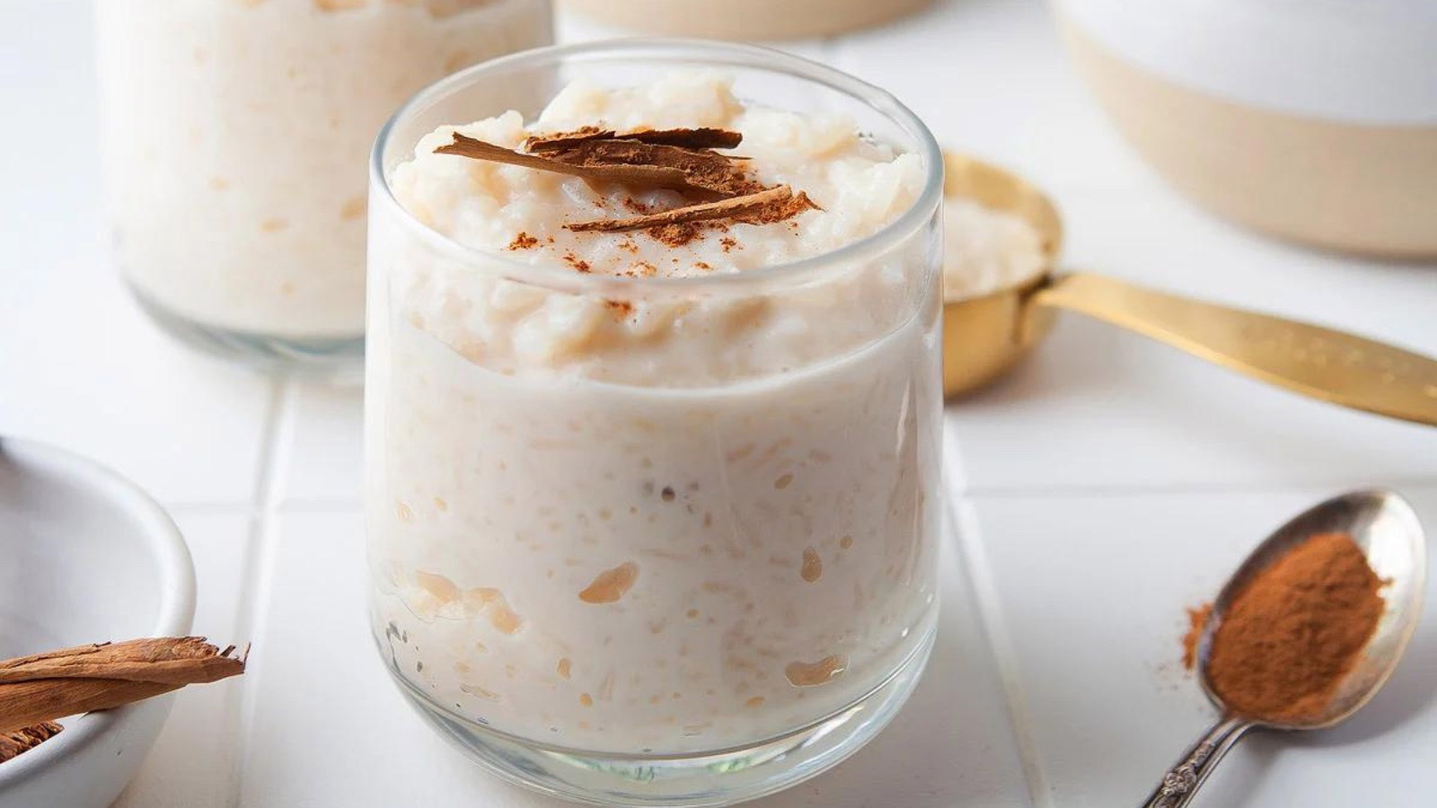 A glass filled with Mexican rice pudding sits on a white countertop.