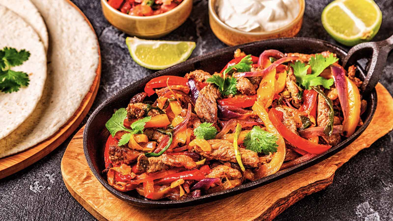 Pork fajitas with colored pepper and onions, served with tortillas, salsa and sour cream.