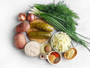 Ingredients for this Red Potato Salad Recipe gathered on a white surface.