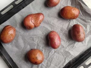 Red potatoes on a parchment-lined baking sheet.