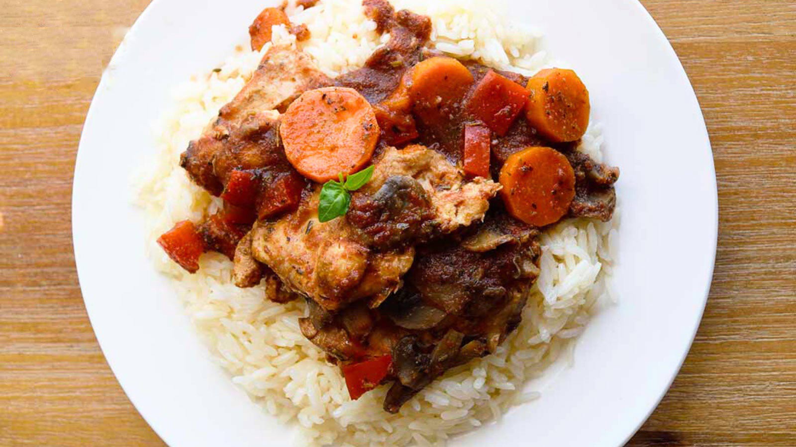 And overhead view looking down onto a plate of Slow Cooker Chicken Cacciatore over white rice.
