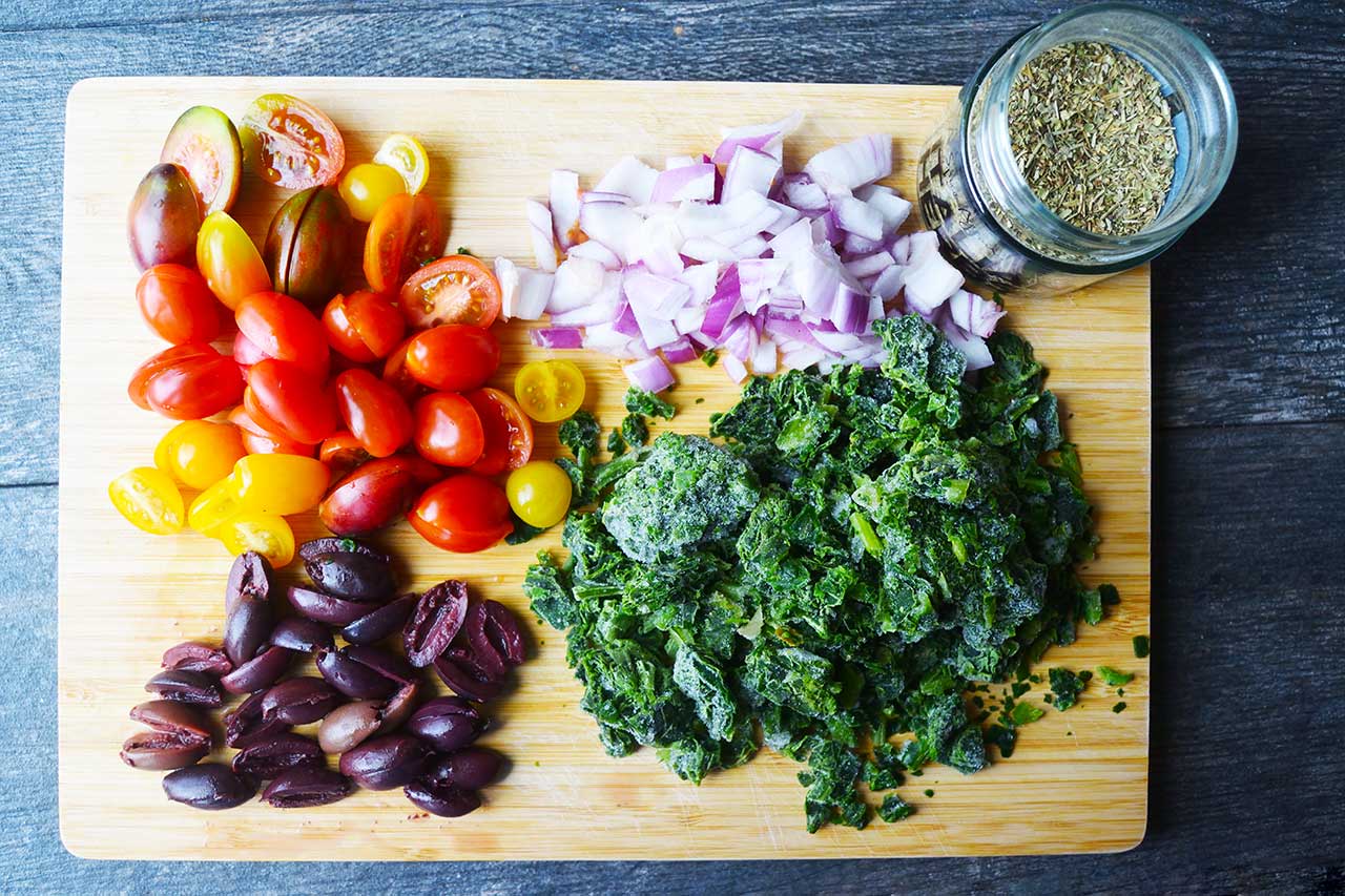 Spinach quiche additions on a cutting board.