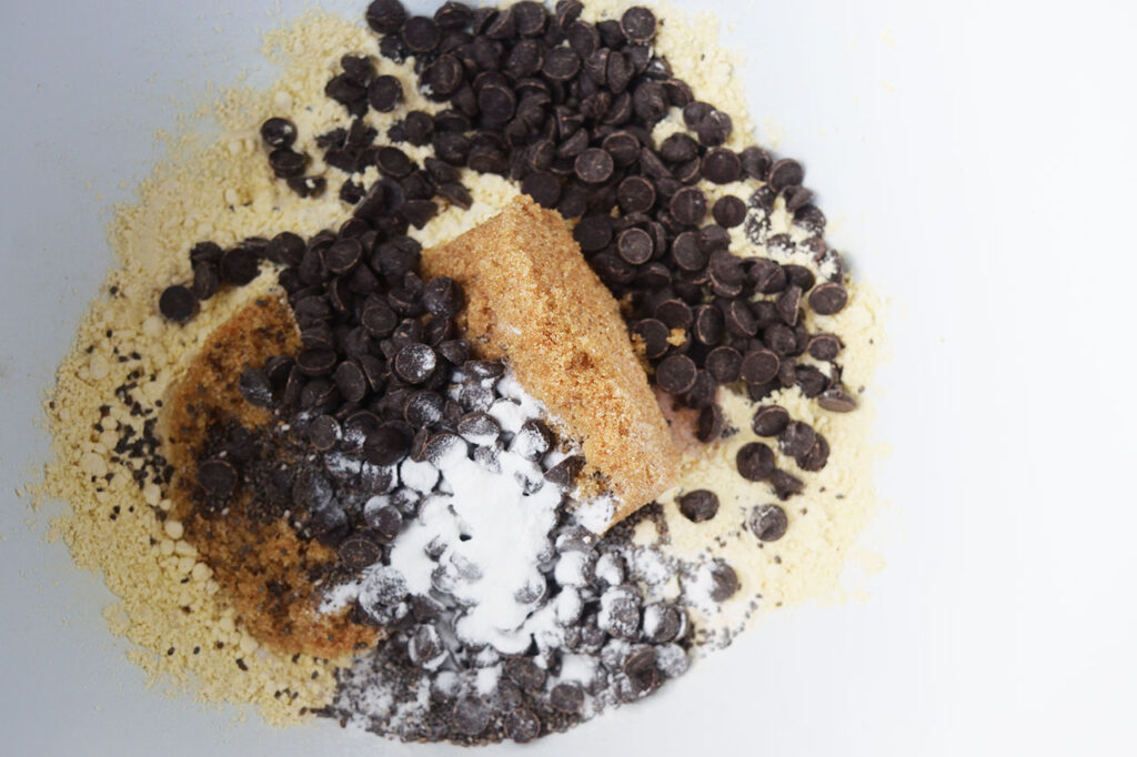 Dry ingredients added to a white mixing bowl.