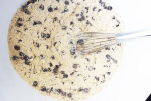 Dry ingredients whisked together with a whisk in a white mixing bowl.