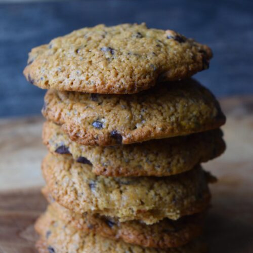 A stack of Superfood Chocolate Chip Cookies on a cutting board with a gray background.