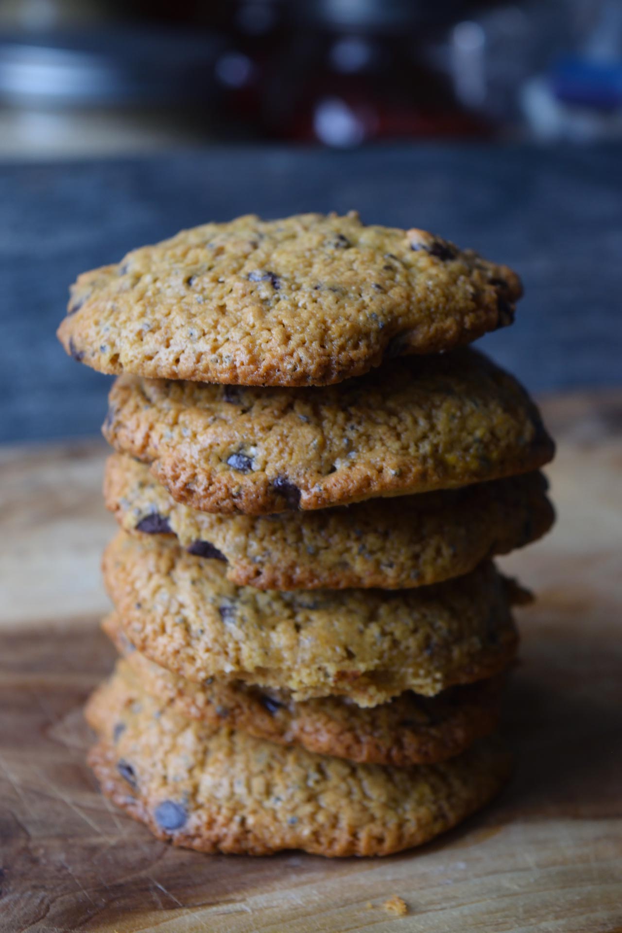 A stack of Superfood Chocolate Chip Cookies on a cutting board with a gray background.