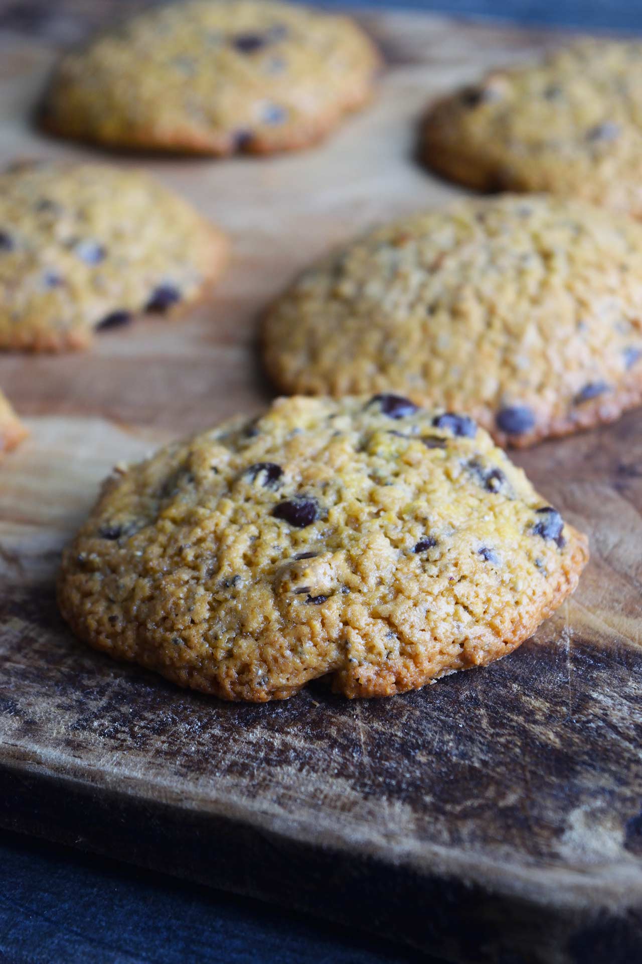 A front view of six Superfood Chocolate Chip Cookies lined up on a cutting board.