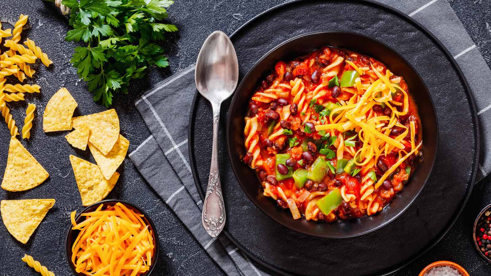 An overhead view of a bowl of taco soup in a black bowl.