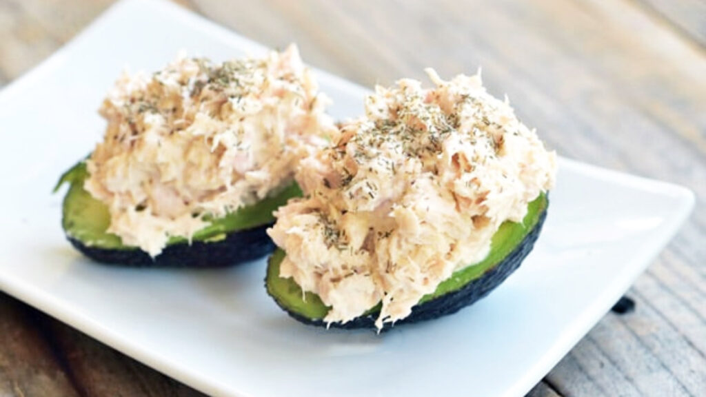 Two avocado halves stuffed with tuna salad.