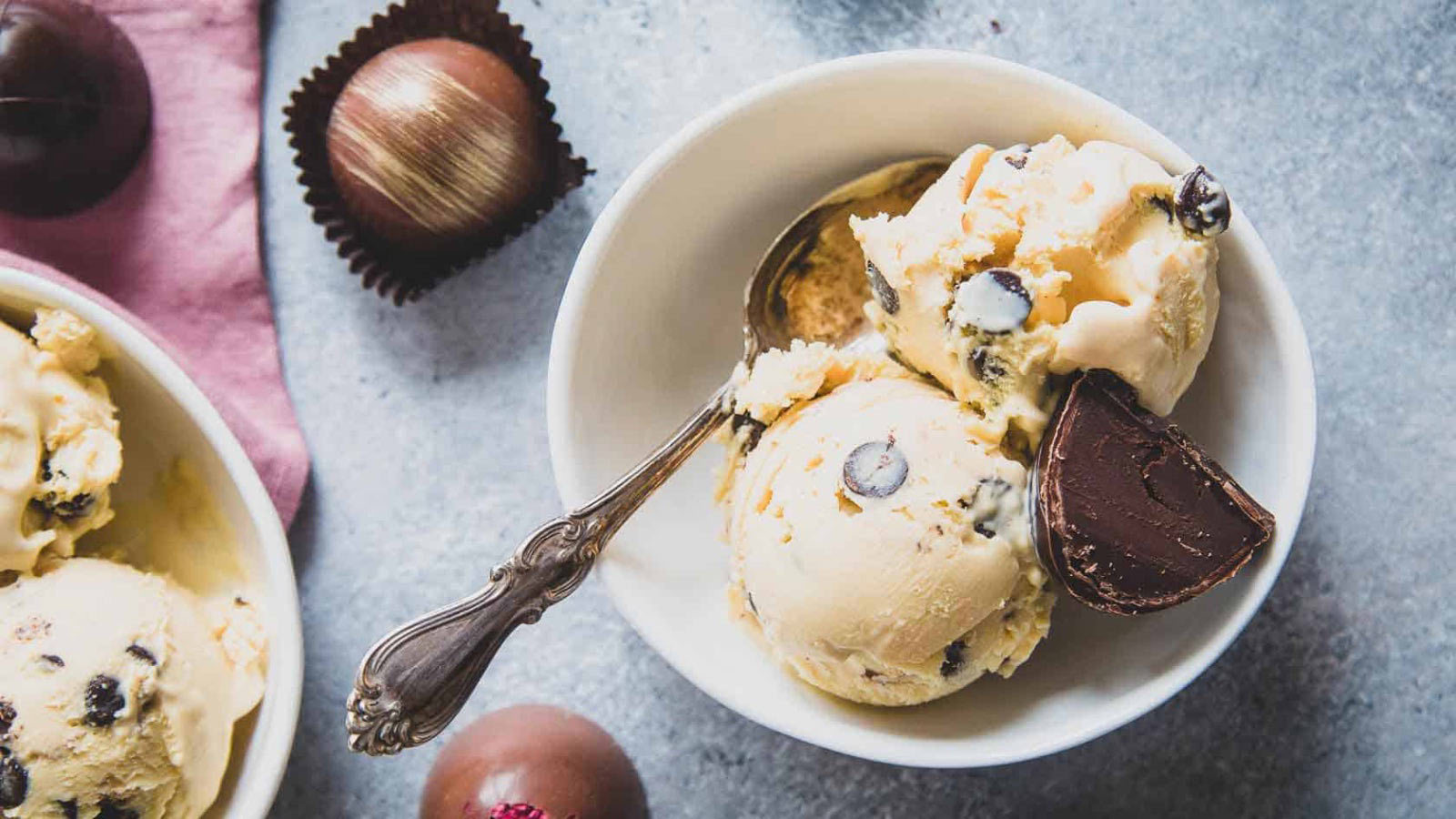 Two scoops of bailey's ice cream in a bowl with a spoon.