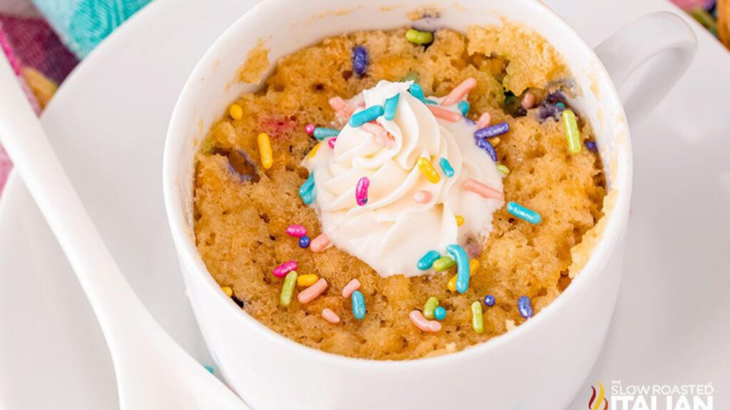 A white mug filled with golden Oreo mug cake.