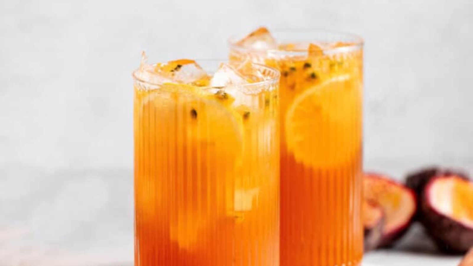 Two glasses filled with ice and passionfruit iced tea.