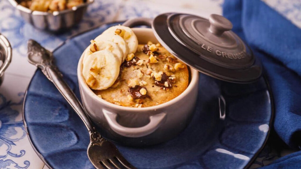 A small crock with a single-serving banana bread in it.